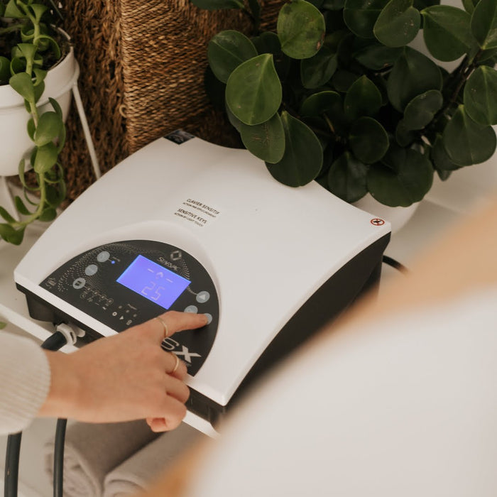 Un utilisateur règle l'unité de contrôle de l'appareil PSX O'terra pour une séance de pressothérapie et de stimulation lymphatique.