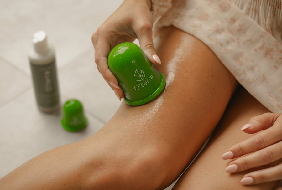 Gros plan sur une main utilisant la ventouse verte O'terra pour masser une cuisse afin de réduire l'apparence de la cellulite.