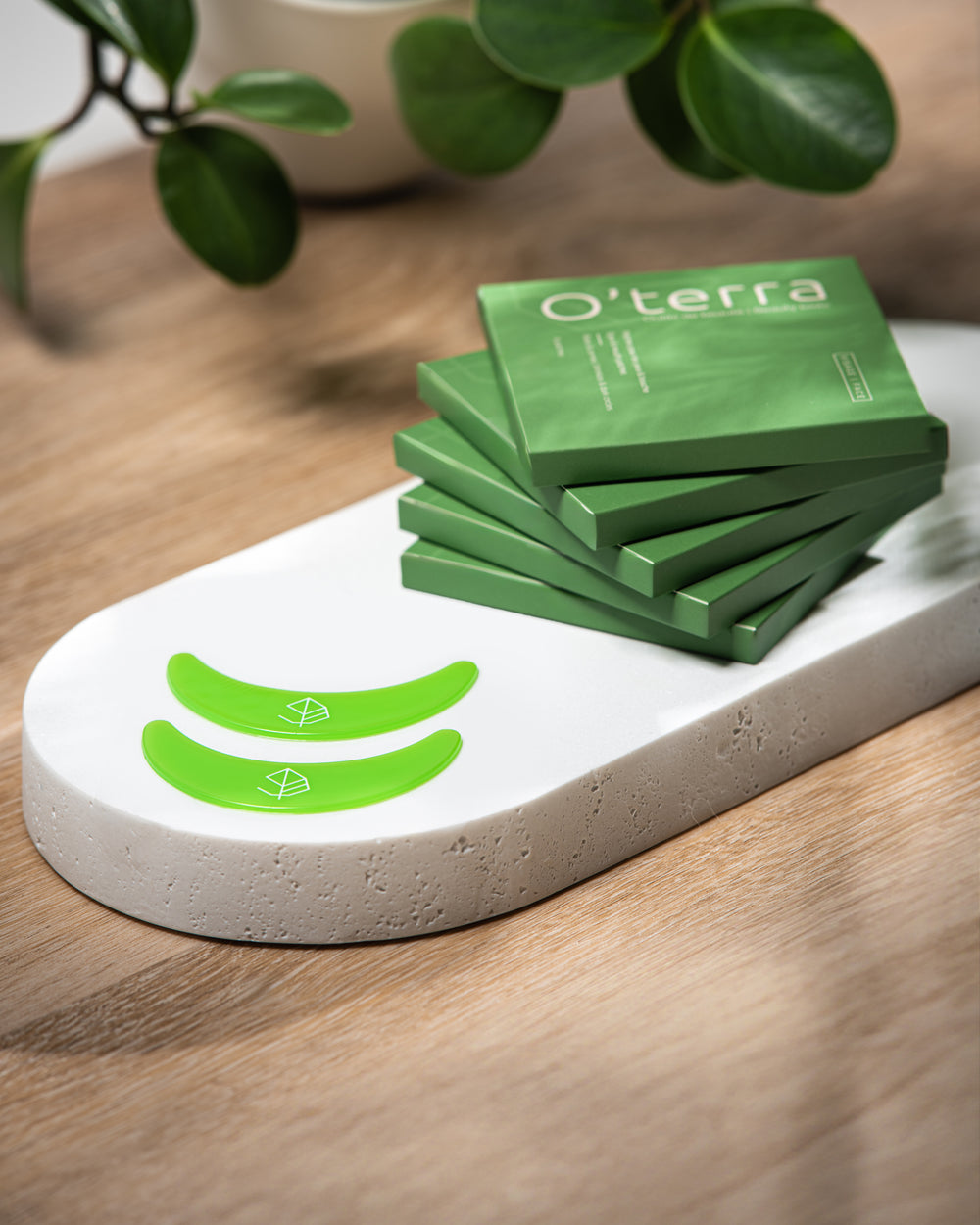 Duo de patches pour les yeux en silicone vert O'terra présentés sur un support blanc devant leurs emballages écologiques.